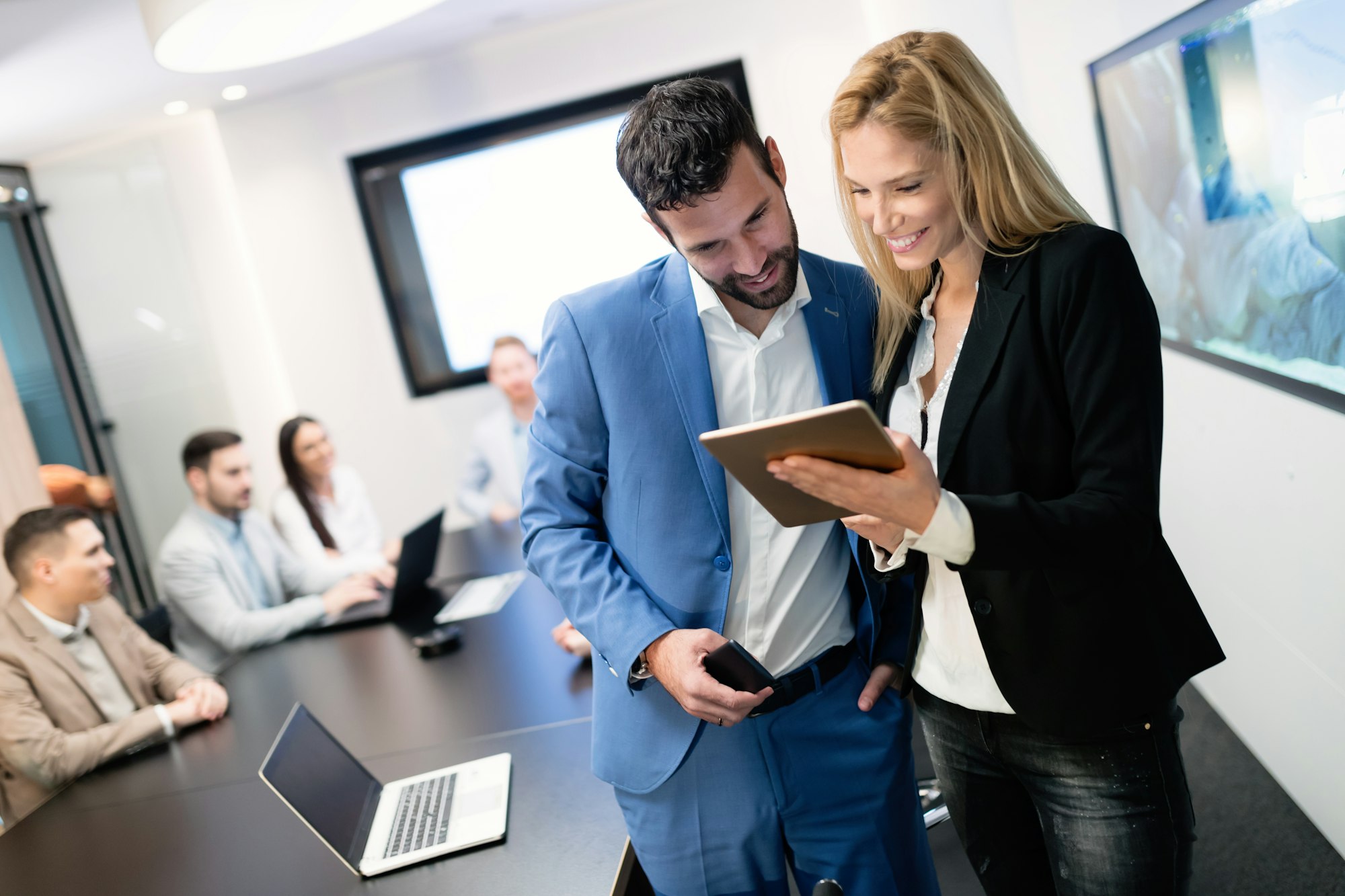 Attractive business couple using tablet in modern office